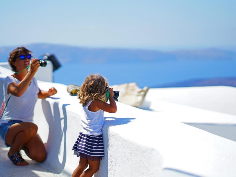 Mom taking picture of kid taking picture in Santorini KidsLoveGreece.com