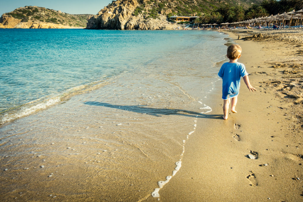 baby boy walking on sandy beach, Crete, Greece