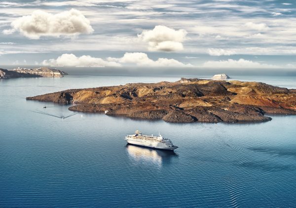 Beautiful landscape with sea view. Cruise liner at the sea near the Nea Kameni, a small Greek island in the Aegean Sea near Santorini, cyclades, Greece SH-min