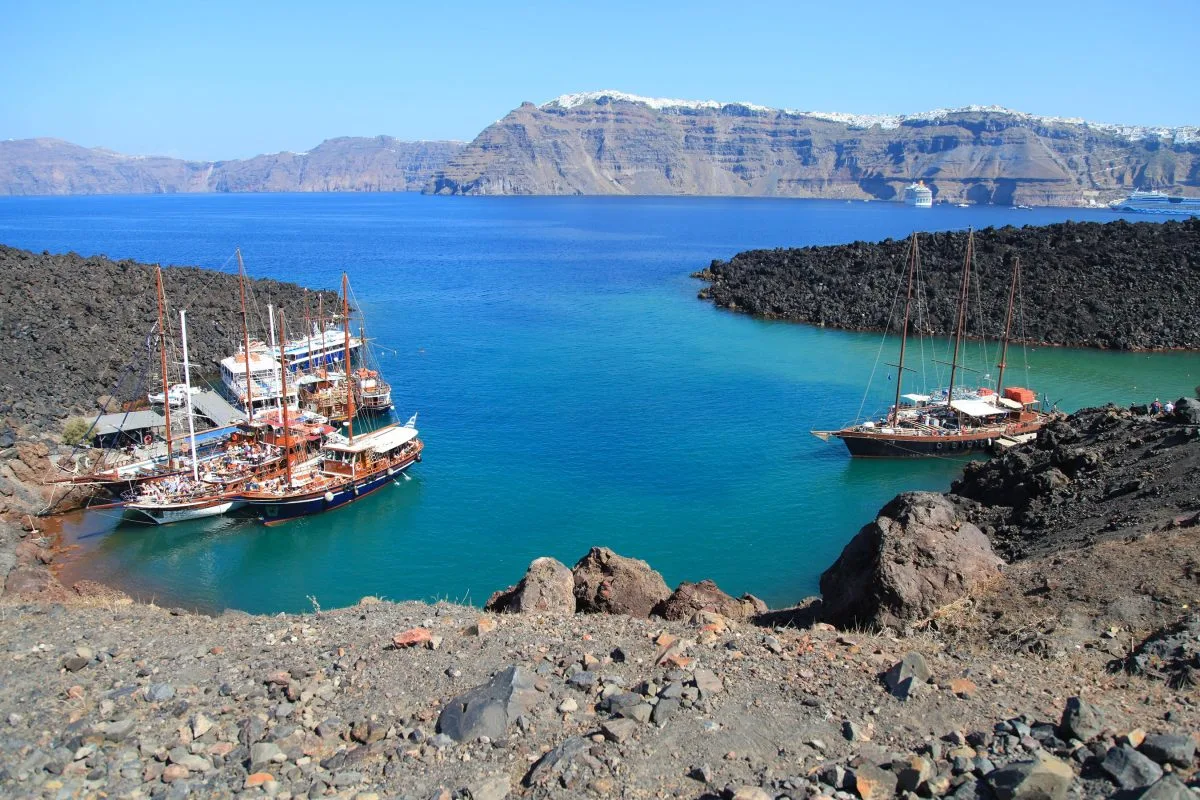 Tourist excursion boats at small port on volcano of Santorini SH-min