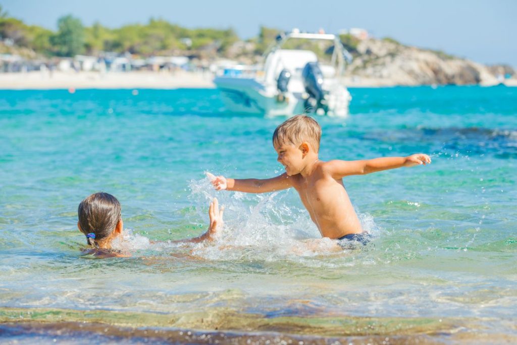 summer_in_greece_kids_playing_in_the_sea_shutterstock